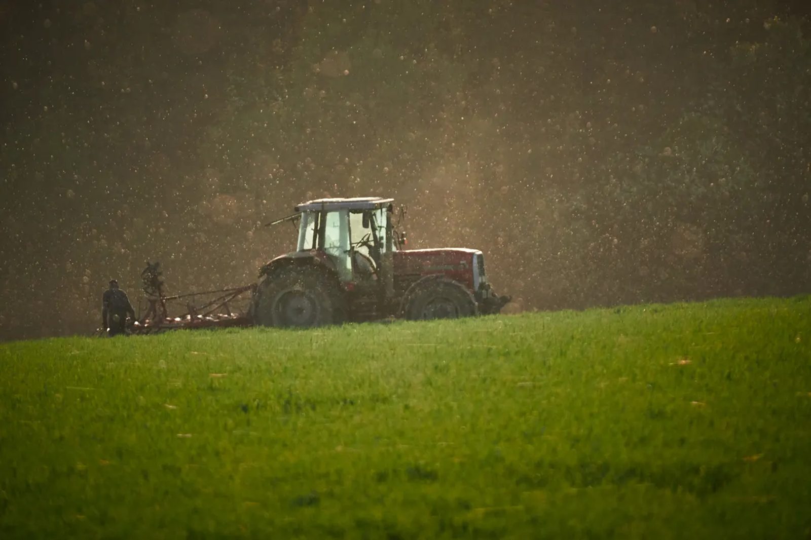 A tractor working across a cultivated field